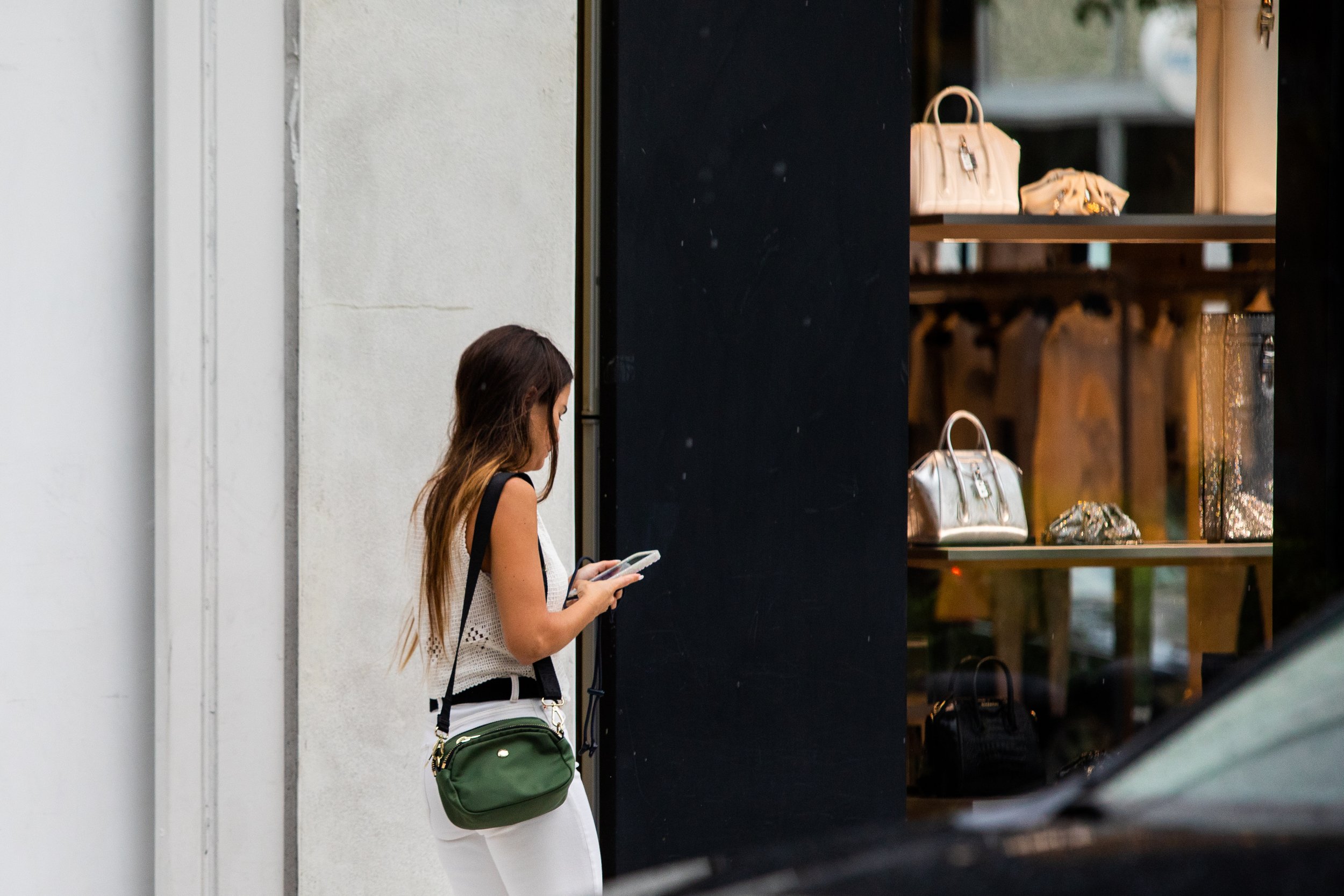 Woman luxury shopping in Miami while looking at phone
